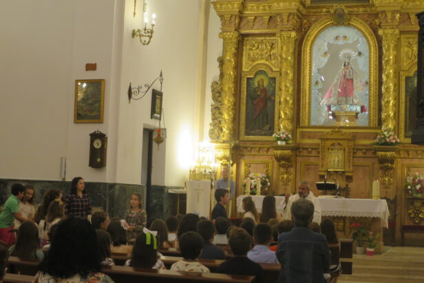 Decenas de niños y niñas que han recibido la primera Comunión este año, rinden pleitesía a la Patrona, Nuestra Sra de Riansares en el Santuario, besando su manto y posando ante la imagen en su camerino